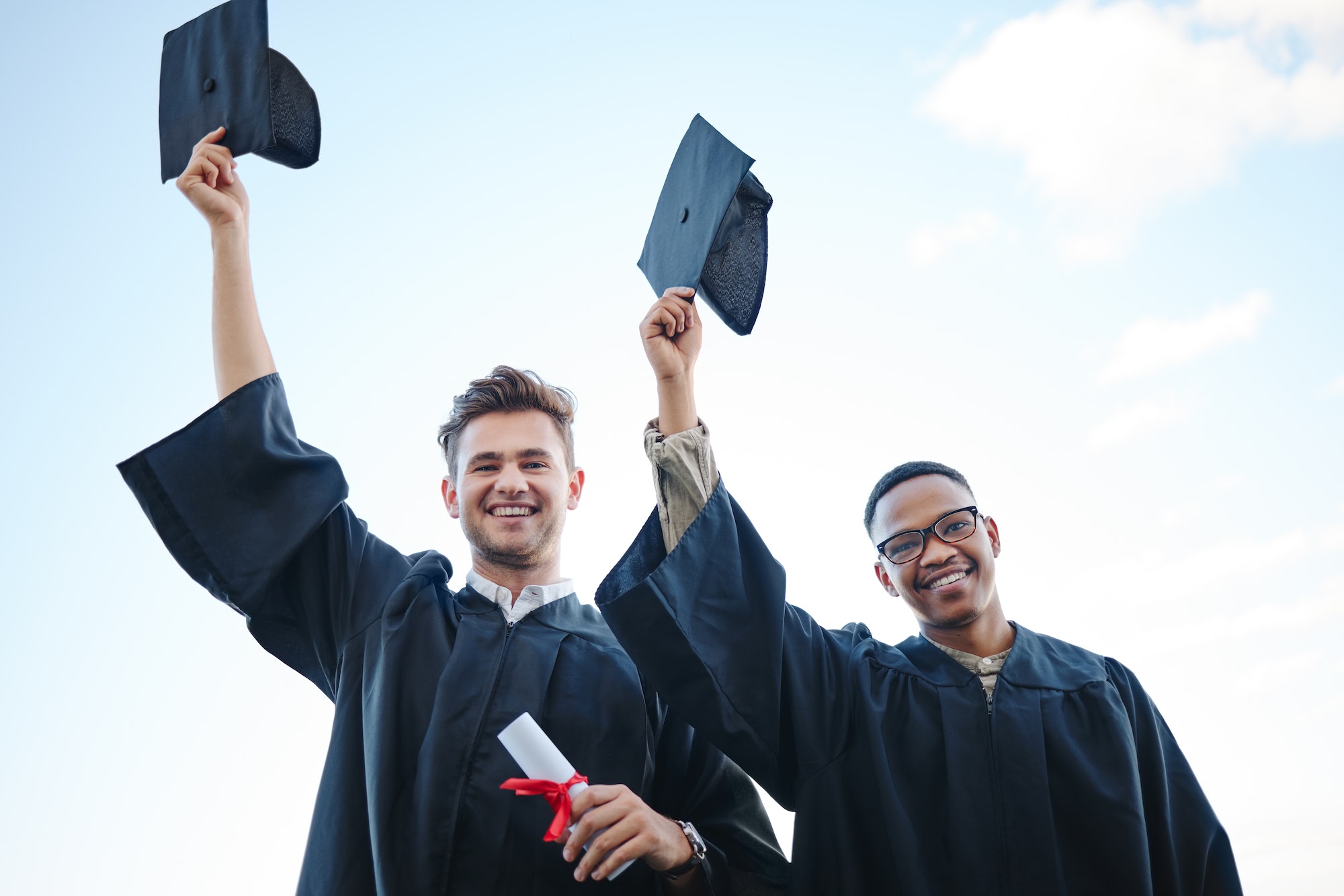 Graduation, education and students with blue sky happy with success in university, college or schoo